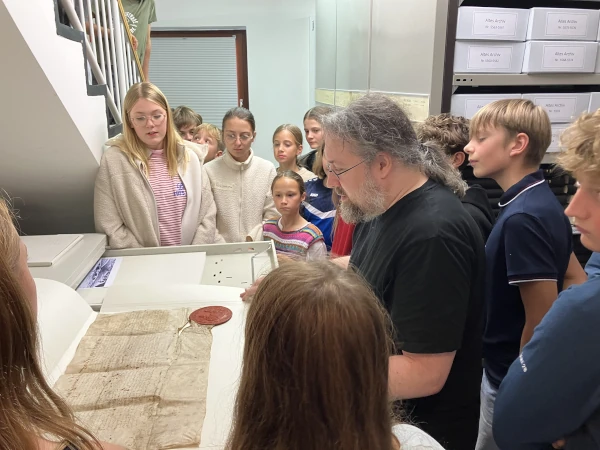 Schülerinnen und Schüler sichten eine alte Schrift im Emslandmuseum